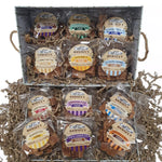 An open whitewash effect gift box bursting with 12 fudge bags. The fudge bag flavours are: chocolate, after dinner mint, belgian white chocolate, crumbly butter, honey, sea salted caramel, cherry bakewell, cumbrian rum and raisin, clotted cream, banoffee, triple chocolate, cointreau and orange.