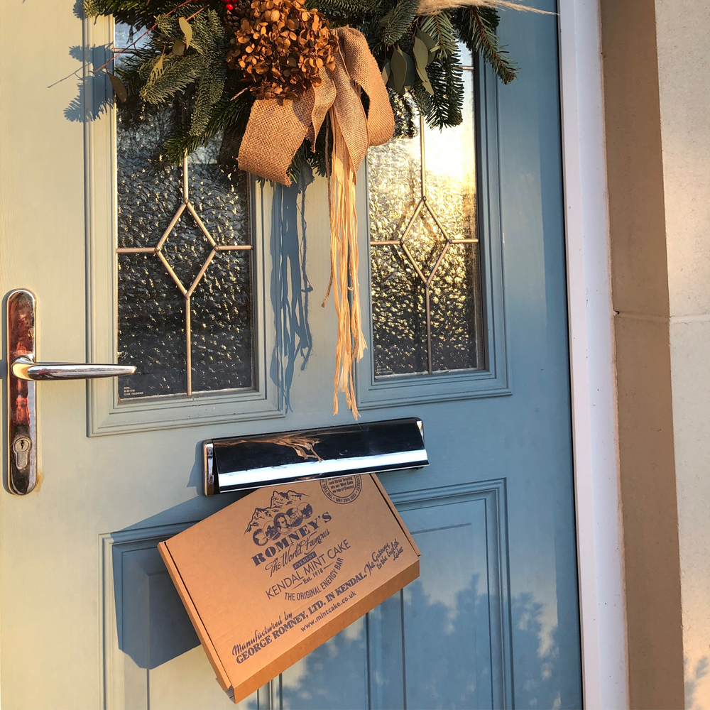 A photo of a door with a letterbox gift sticking out of the letterbox hole