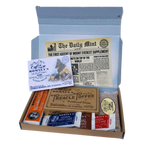 An open rectangular cardboard box containing a variety of Romney's confectionery products such as: rum and butter bar, winter candy bar, 40g white kendal mint cake, 40g brown kendal mint cake, 40g chocolate coated kendal mint cake, butter tablet bar, box of old fashioned treacle toffee