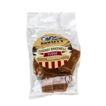A transparent bag containing pieces of Fudge. The bag has a label on it that shows Romney's logo and says 'Cherry Bakewell Fudge'.