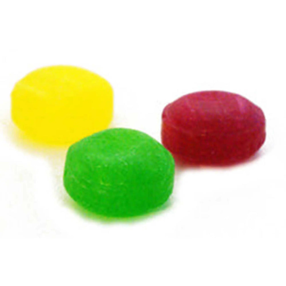 Three unwrapped Fruit Drops. One is yellow, one is green and one is red.
