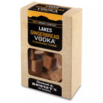 a rectangular cardboard box containing a transparent bag of fudge. The box has a black and yellow label that states 'Lakes Gingerbread Vodka Flavoured Fudge.