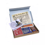 An open rectangular cardboard box containing a variety of Romney's confectionery products such as: rum and butter bar, winter candy bar, two 40g chocolate coated kendal mint cake bars, 170g white kendal mint cake, 170g brown kendal mint cake bar, white kendal mint cake pocket tin