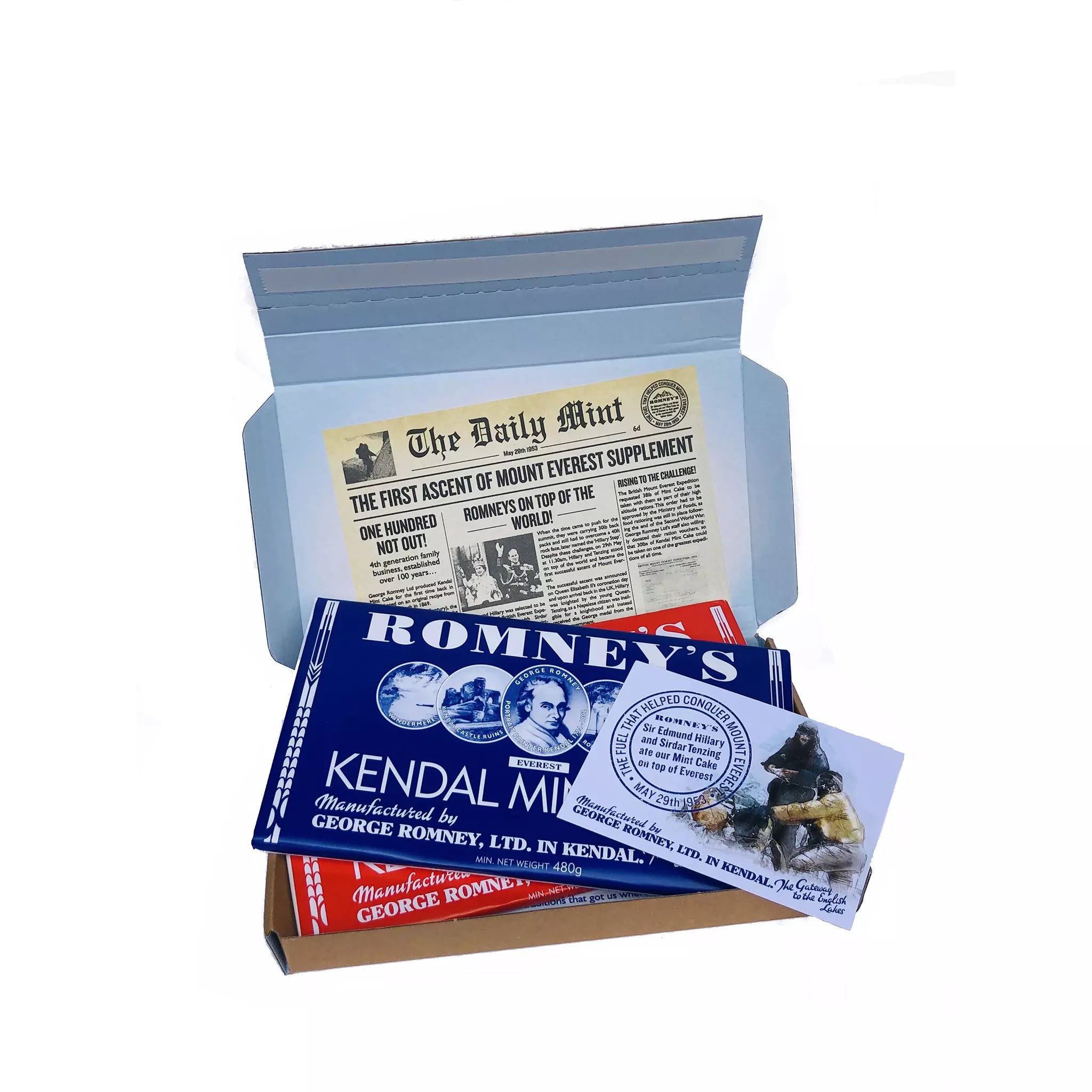 An open rectangular cardboard box containing a variety of Romney's confectionery products such as: A 480g white kendal mint cake bar and a 480g brown kendal mint cake bar