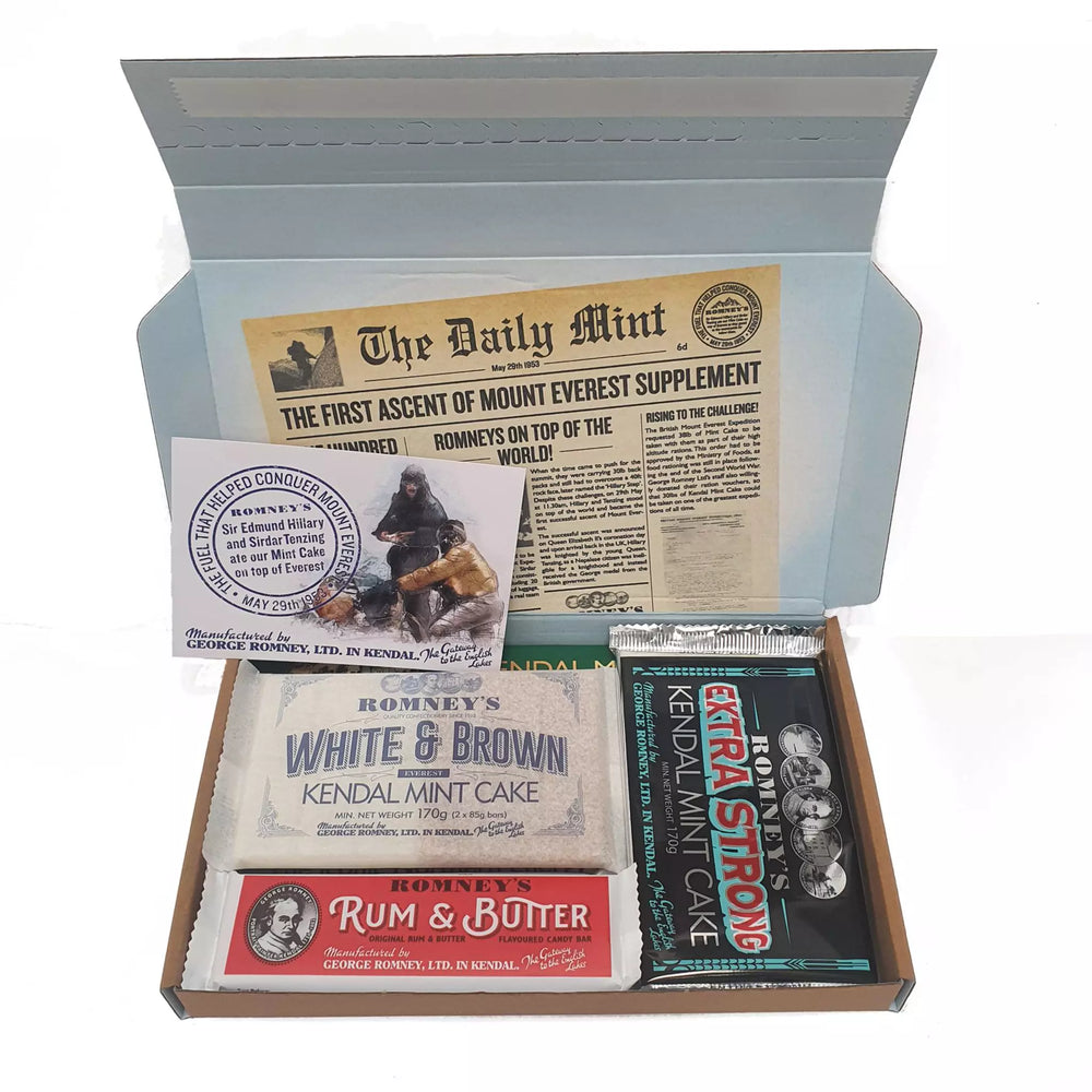 An open rectangular cardboard box containing a variety of Romney's confectionery products such as: rum & butter bar, winter candy bar, extra strong kendal mint cake bar, twin kendal mint cake bar, kendal mint cake fingers selection