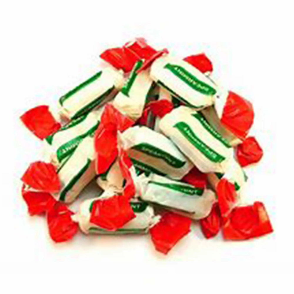 A pile of wrapped Spearmint Chews. The wrappers are white and green with red tips.