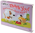 A pink rectangular box featuring a cartoon grass landscape and a dog. The words 'Thank you! For looking after my dog' are written in a red font. The box contains 300g of clotted cream fudge.